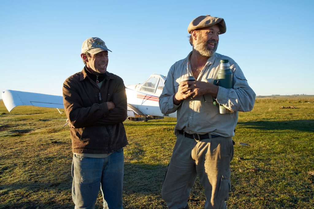 Farm Tres Rincones bei Artigas, Martin Echenagusia, der Besitzer ( rechts im Bild mit Mathetee ) und sein Pilot, der an diesem Tag zum Düngen der Weiden gekommen ist, Uruguay Mai 2017